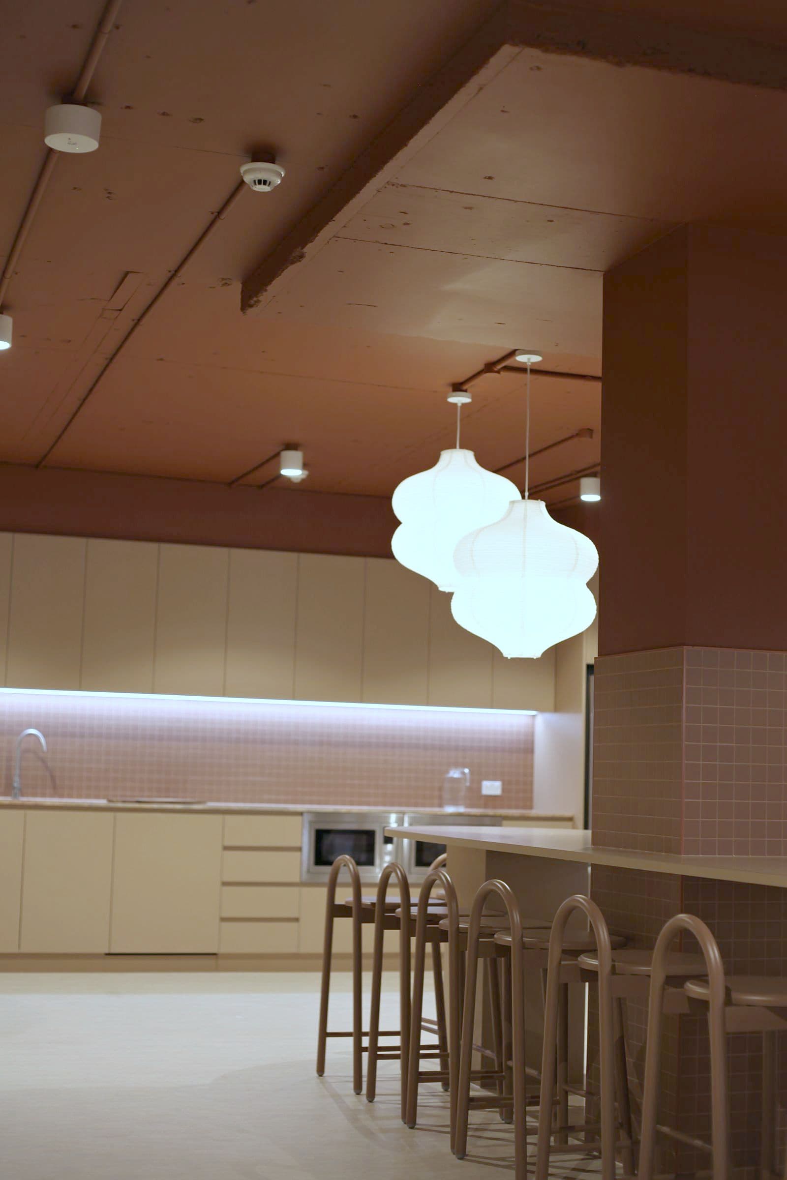 The café bar with pendant lights and timber stools at Workspace by black vc